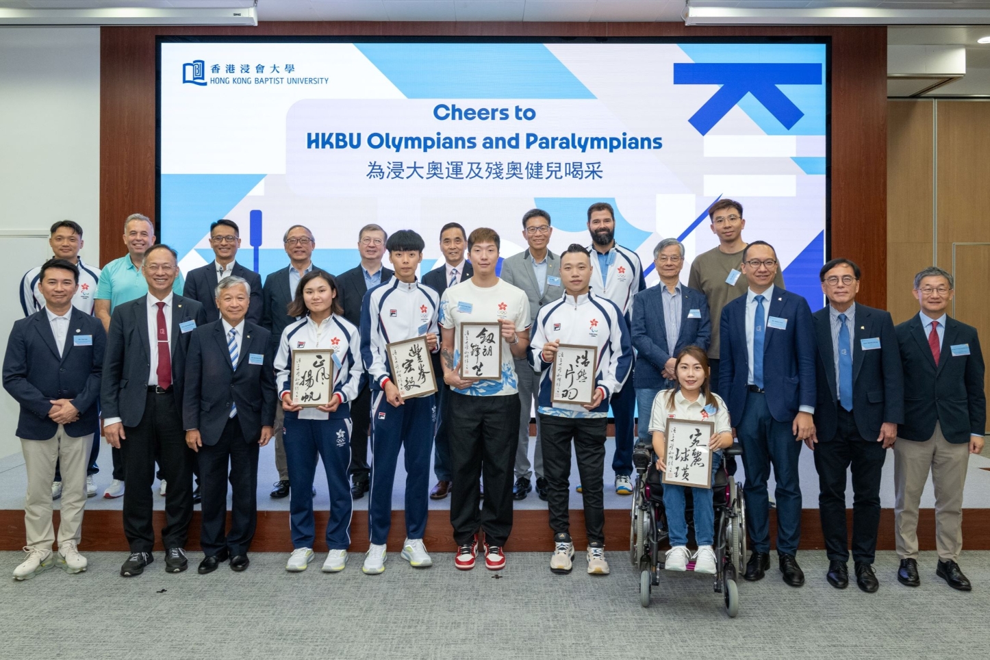 A group comprising athletes, coaches, and distinguished VIP guests pose for an event photograph