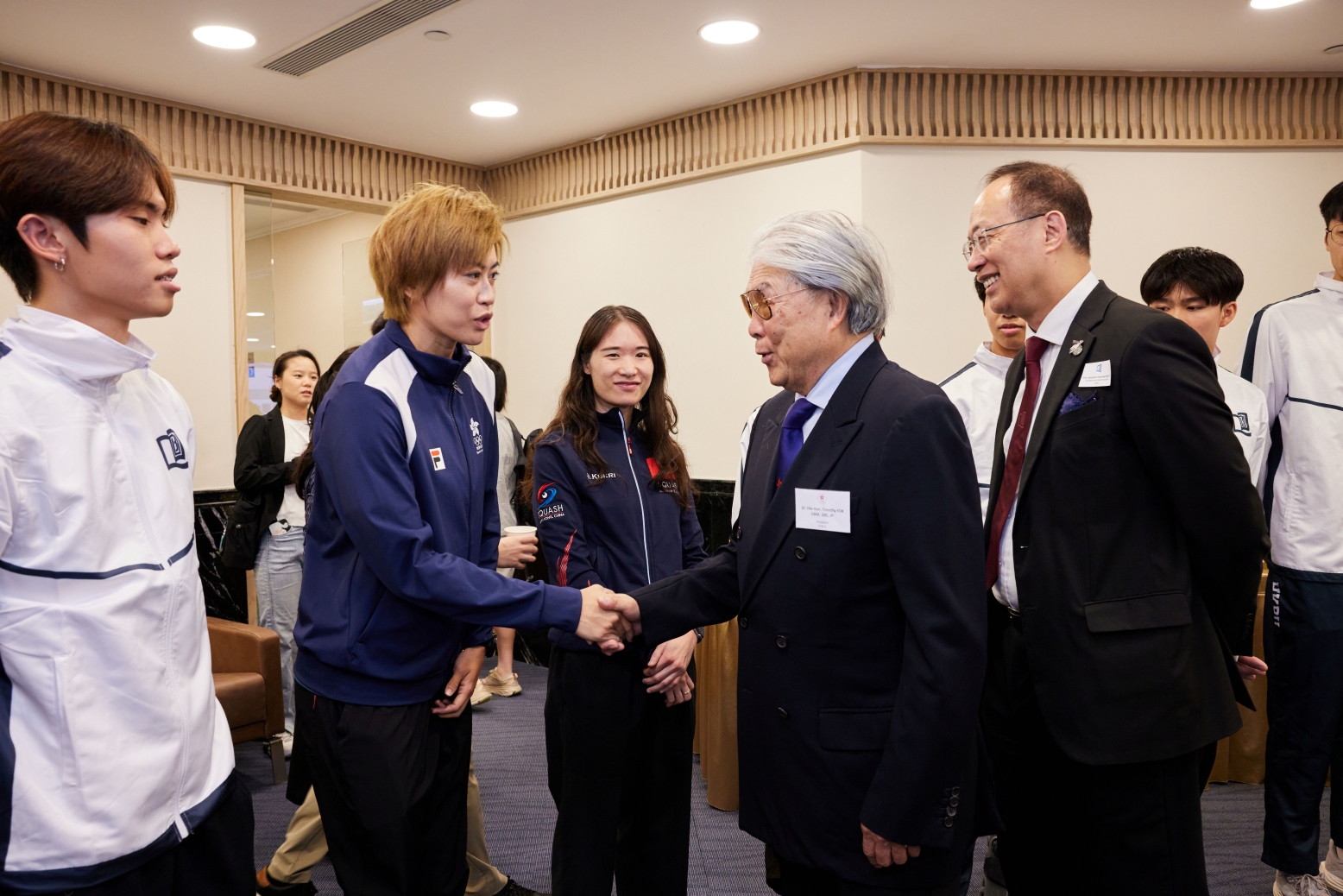 Dr. Timothy Fok shaking hands with alumna Poon Pak Yan, a former rugby and athletics athlete
